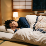 Woman sleeping on a futon mattress in a traditional Japanese room