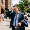 Businessman wiping sweat outdoors in summer